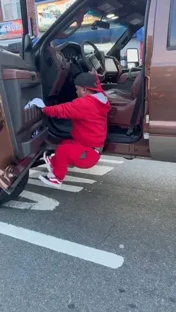 Little person jumps up into a big truck