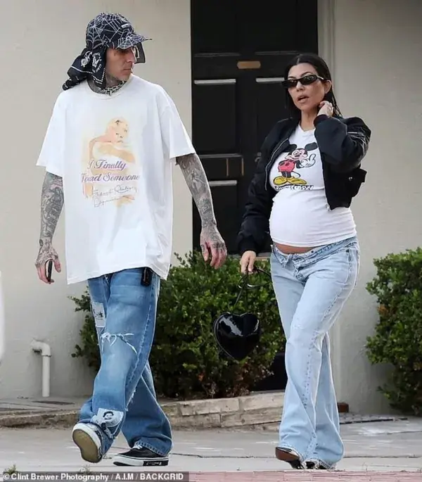 Pregnant Kourtney Kardashian spotted with husband Travis Barker, flaunting baby bump.