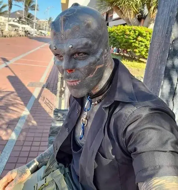 A MAN has transformed himself into a 'black alien'