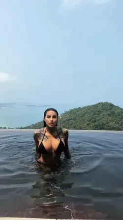 A Tattooed Beauty Emerges from the Water in a Striking Black Bikini