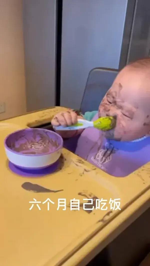 A six-month-old baby learns to eat.