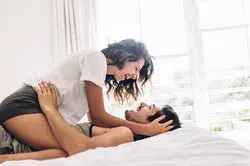 Playful young couple on bed