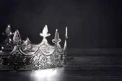 Silver Metal King or Queens Crown on a black Wood Table