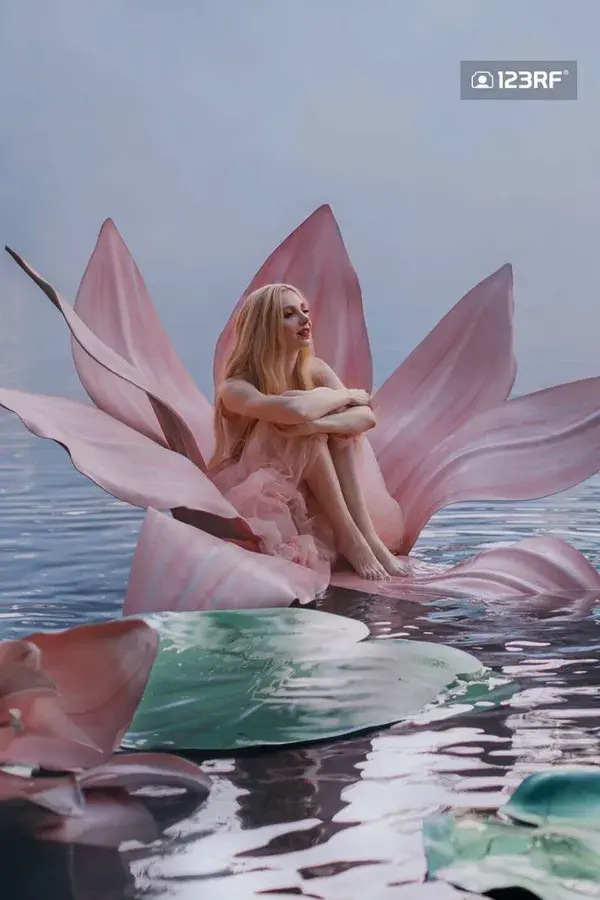 photo of a young woman in a huge pink flower in water