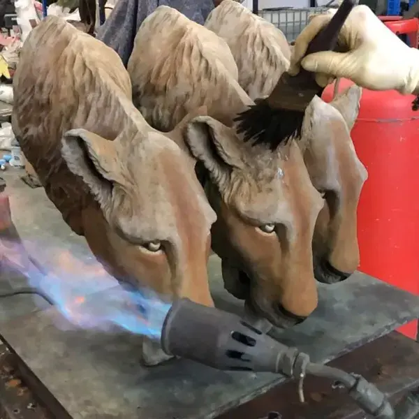 Applying the finish to  A Trio of Lions bronze