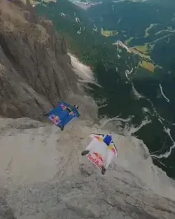 Wingsuit flyers followed by drone