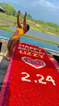 Woman falls into a pool with a birthday message made out of flower petals