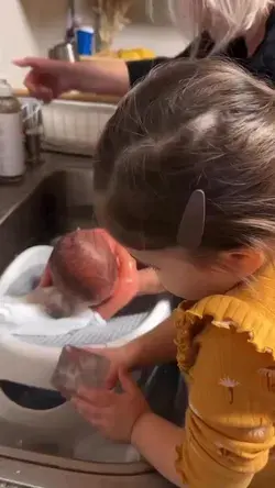 The big sister’s helping the grandma to give her baby brother his first bath 👶🏻💕🥰