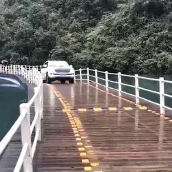Car drives over floating bridge 